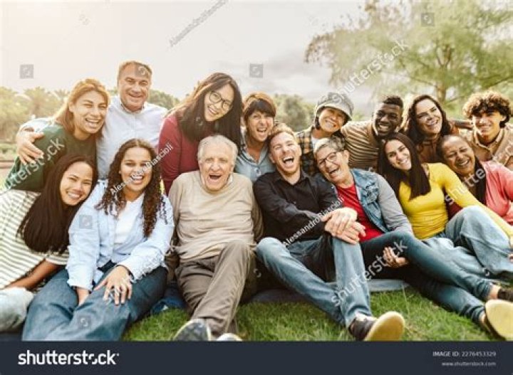 A group over people are sitting around a table having a meeting. | Photo: Shutterstock