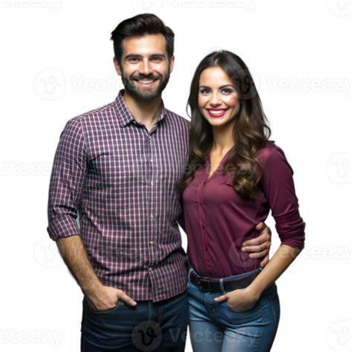a man and woman standing next to each other in front of a truck on the street