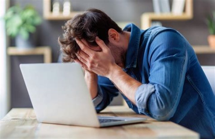 A photo of a frustrated young man with his hand on his face. | Photo: Unsplash