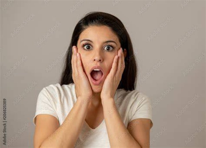 A woman looks shocked in front of a man. | Source: Shutterstock