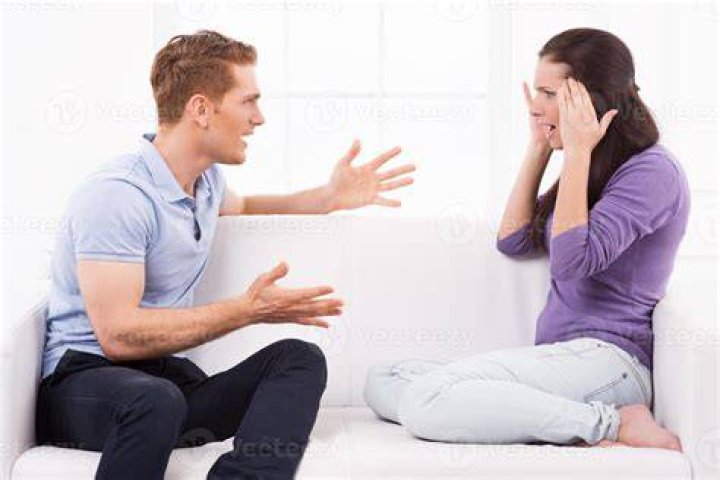 A woman shouting while sitting behind a man | Source: Shutterstock
