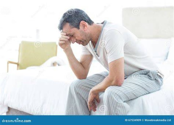 A worried man sitting on his bed | Photo: Shutterstock