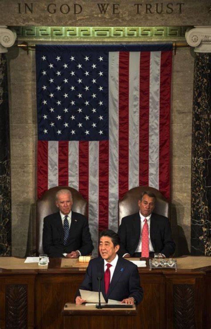 Abe flanked by by Vice President Joseph Biden (L) and House Speaker John Boehner (R) gets a standing ovation while speaking to a joint session of the United State Congress on April 29, 2015