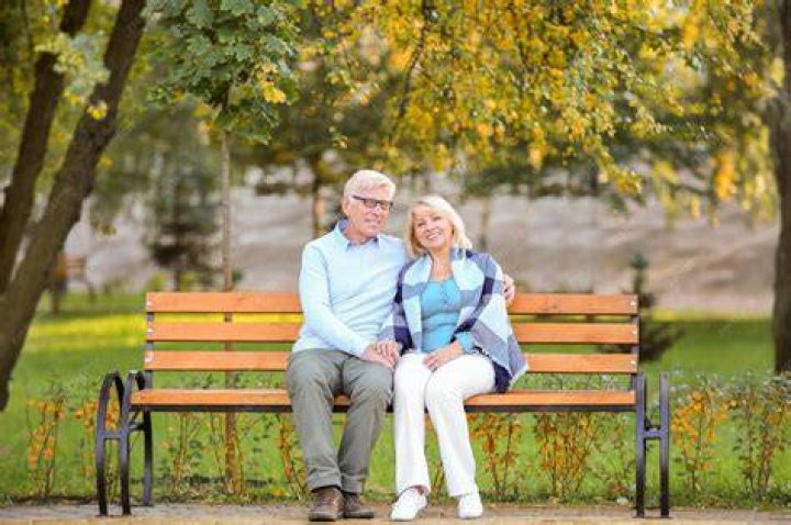 An elderly couple sitting on wooden bench. | Photo: Pexels