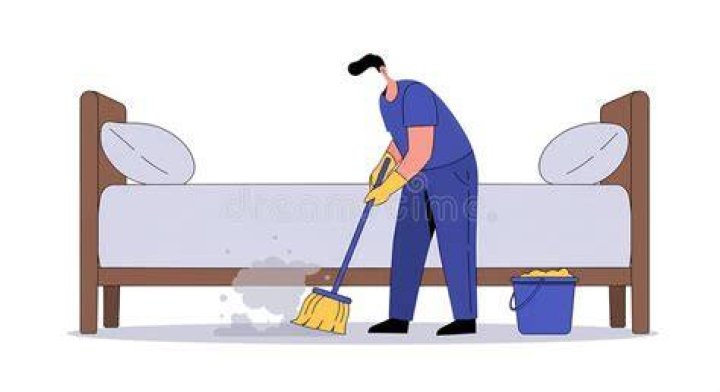 Broom sweeping under the bed | Source: Shutterstock.com
