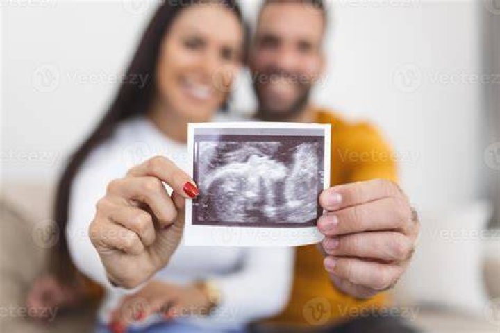 Couple holding an ultrasound picture of their baby | Photo: Unsplash/kellysikkema