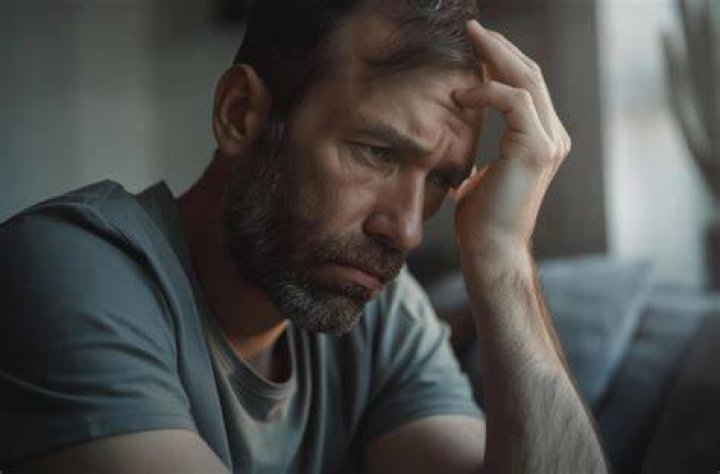 Distressed man feeling doubtful about something while holding his phone | Source: Shutterstock
