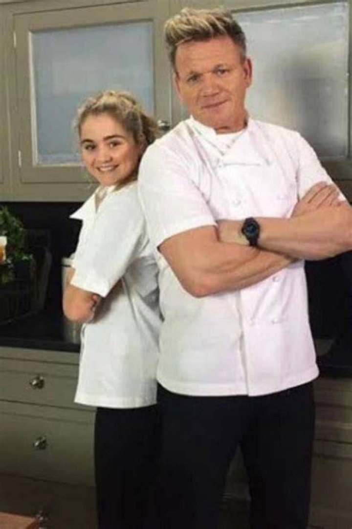Father and daughter: Gordon Ramsay looked smart in a black suit as he stood on the balcony with his daughter Holly, 22, who stunned in a clinging black gown with a daring side split