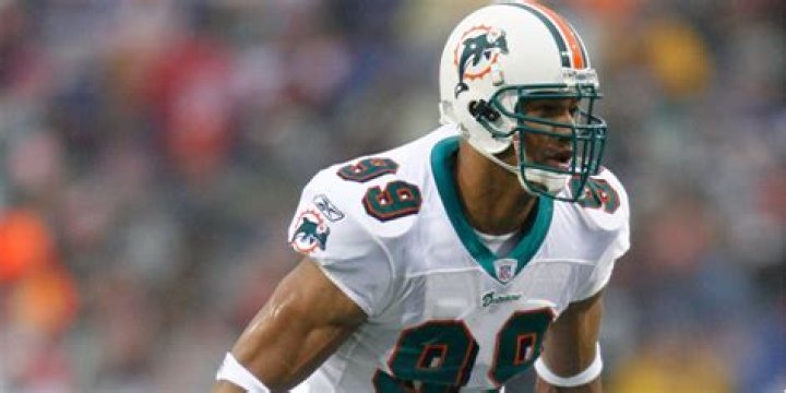 Former Miami Dolphins player Jason Taylor goes to kiss his wife, Katina, as he and Zach Thomas