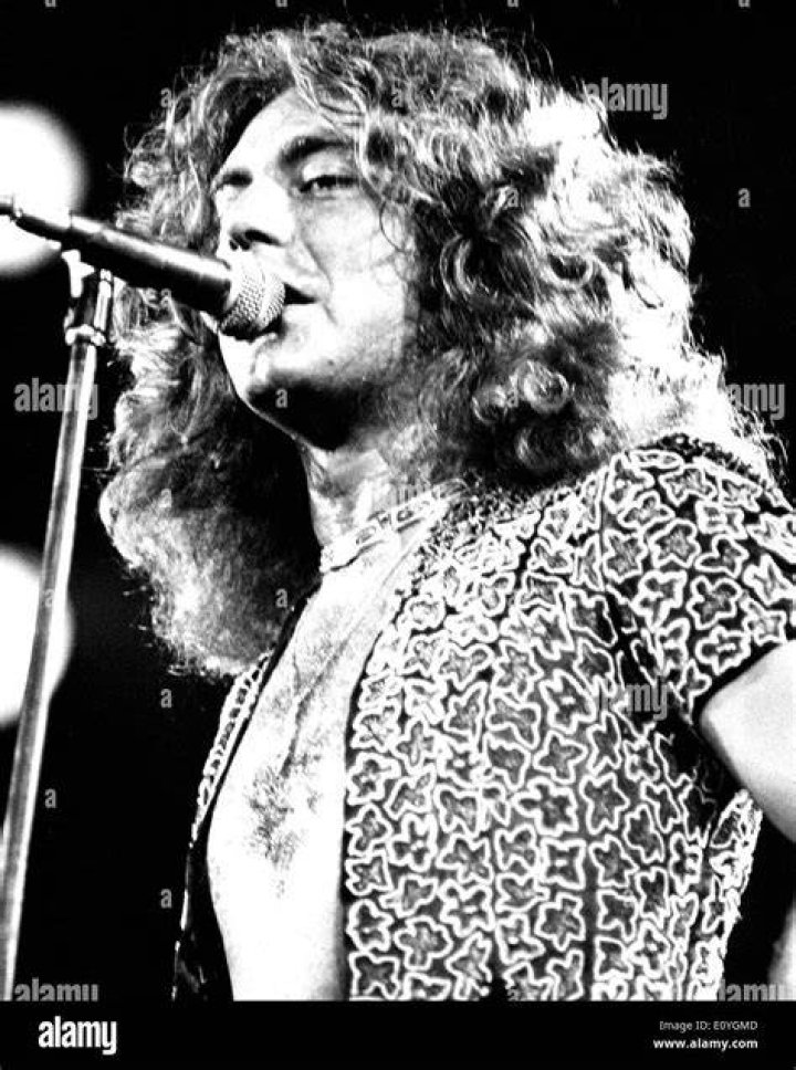 Led Zeppelin singer Robert Plant wears a red shirt as he holds the microphone during a 1983 concert in Detroit.