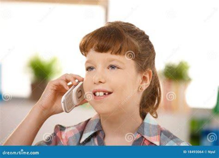 Little girl using cellphone. | Photo: Shutterstock
