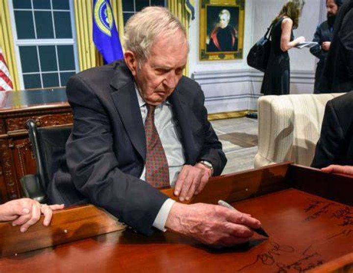 Lyon Gardiner Tyler Jr. signs his name on the inside of a desk drawer with other descendants of past Presidents gathered for a panel discussion at the Kennedy center, on August, 28, 2018 in Washington, DC | Photo: Getty Images