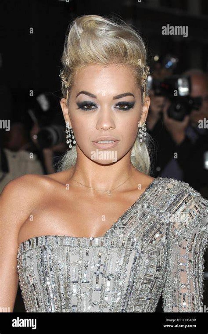 Magnificent: British singer Rita Ora, 32, commanded attention in a high neck form-fitting red dress, with matching leggings peeking out from the bottom