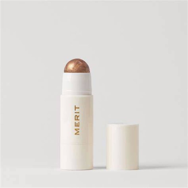 merit beauty day glow highlighter on the left and the author wearing it on the right