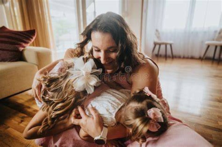 Mother hugging her two little children | Source: Shutterstock