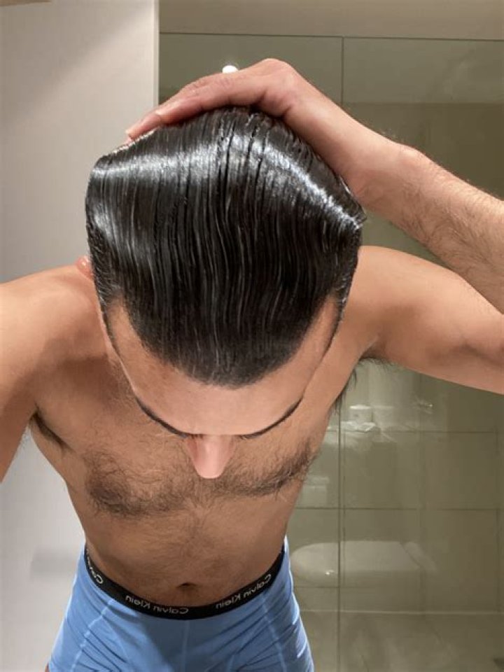Slicked back: Slipping his feet into suede moccasins the property developer wore his blonde locks slicked to one side.