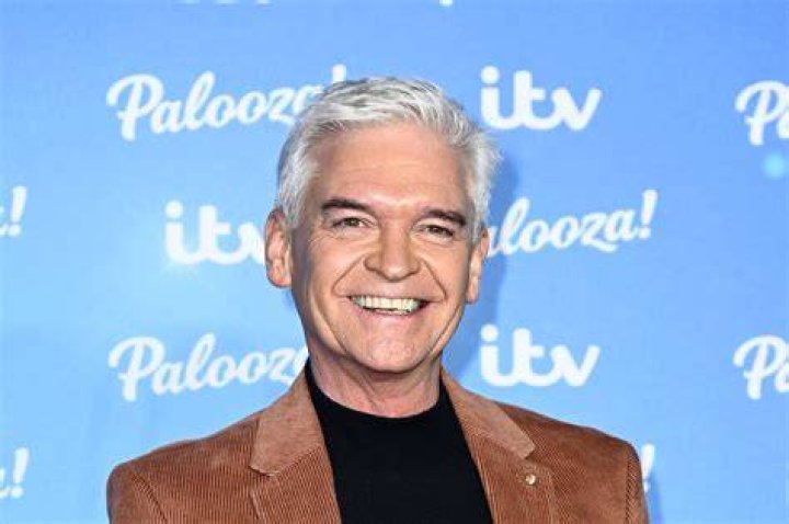 Smart: Phillip Schofield cut a suave figure in a dark grey suit which he teamed with a blue patterned tie and white shirt