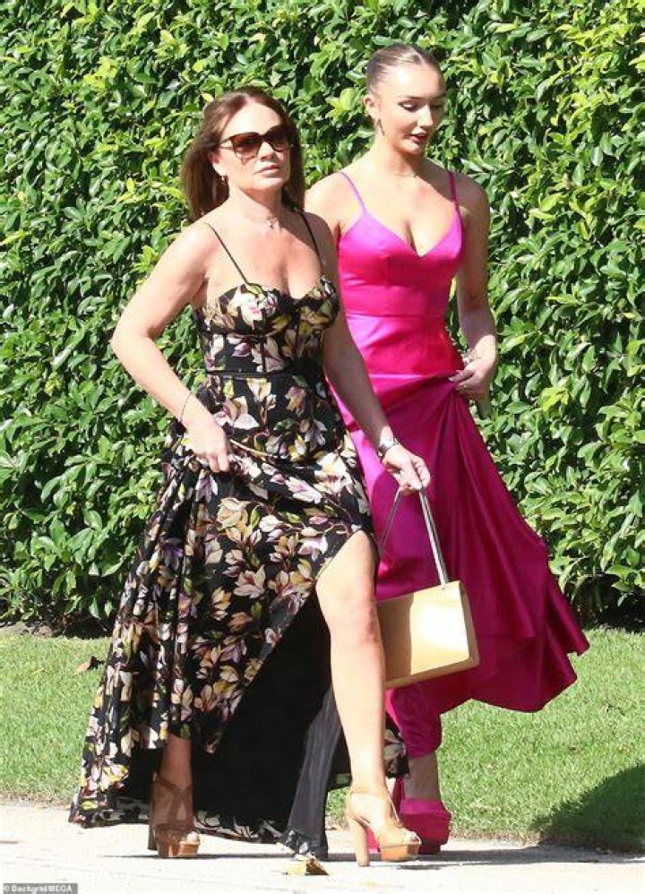 Summery: Louise looked elegant in a stunning strapped floral black gown with a daring side split, which she paired with beige heels and a gold handbag