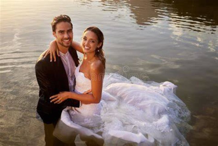 The couple celebrate their wet wedding as a rainbow emerges over them