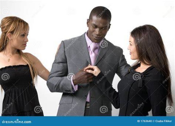 Two women and a man in a cafe. | Source: Shutterstock