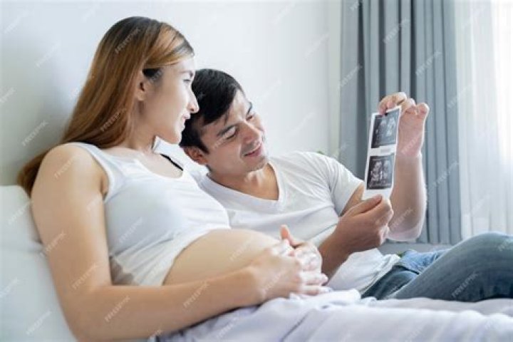 Wife flaunts an ultrasound picture of her baby while her husband plays the piano | Photo: Unsplash/jonathansancheziam
